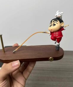 Cute figurine on a wooden base with a balancing toy design, featuring a playful character in a red outfit.