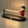 Decorative LED desk lamp with playful figurine design, perfect for kids' rooms and quirky decor enthusiasts.